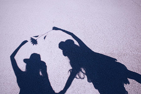 two women shadows on concrete surface thumbnail