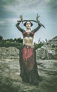 woman wearing red and black dress carrying curved sword thumbnail