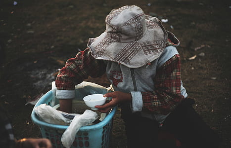 person holding bowl reaching on blue bucket thumbnail