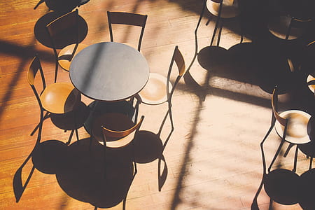 five brown wooden chairs arranged around black wooden table thumbnail