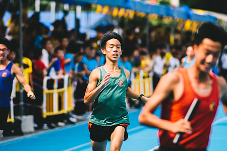 tilt shift lens photography of boy in green tank top and black sports shorts thumbnail
