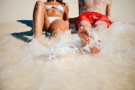 couple lying on white sand thumbnail