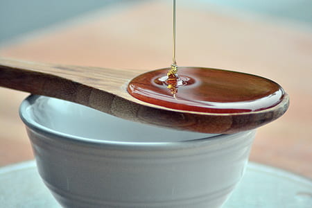 brown liquid pouring on brown wooden spoon thumbnail