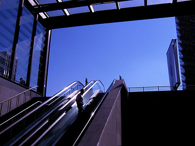 man standing on escalator during daytime thumbnail