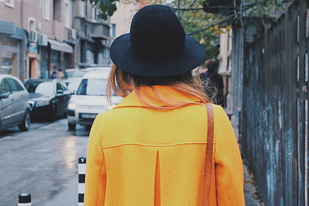 woman in yellow coat with black hat thumbnail