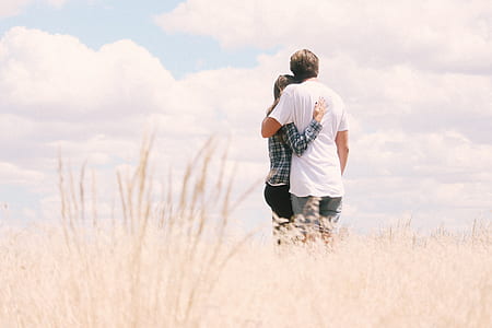 photo of man and white standing on grass field during daytime thumbnail