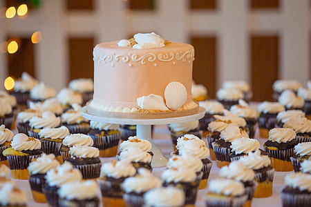 beige fondant cake surrounded with black and white cupcakes lot thumbnail