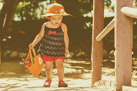 girl holding basket beside brown post thumbnail