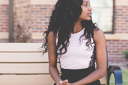 woman sitting on white bench facing sideways thumbnail