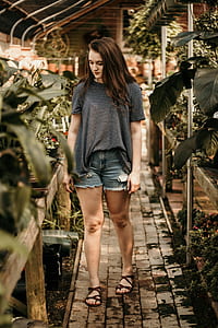 woman standing on pathway between plants thumbnail
