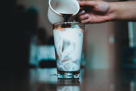 person pouring black liquid in glass cup thumbnail