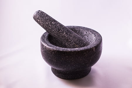 black stone mortar and pestle placed on white surface thumbnail