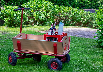red and black toy wagon on green grass thumbnail