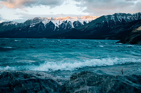 body of water beside mountain thumbnail