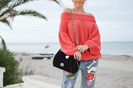 woman standing on elevated ground near sea during daytime thumbnail