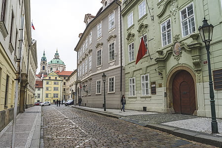 person walking on sidewalk near building on front of other building thumbnail