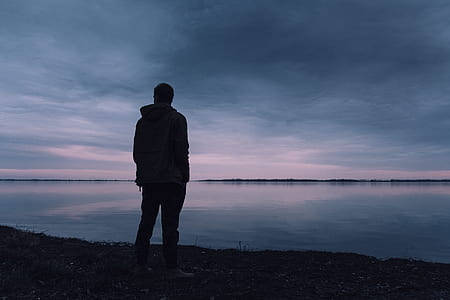 silhouette photo of man near body of water thumbnail