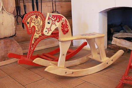 two red and tan rocking horses beside fireplace thumbnail