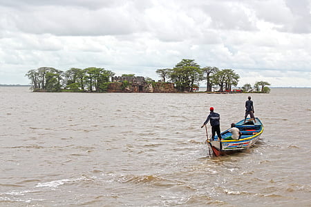 three men on blue boat sailing near island thumbnail