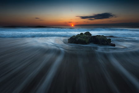 timelapse photography of rock at beach during sunset thumbnail