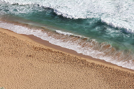 brown sand next to sea with waves thumbnail