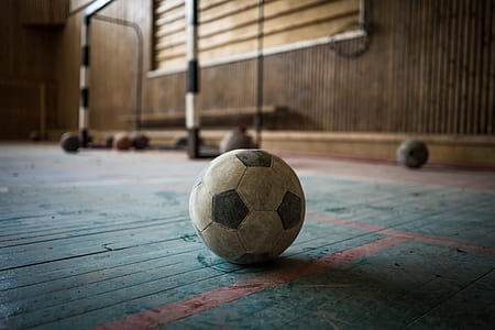 white and black soccer ball placed on blue wooden floor thumbnail