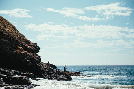 Hikers on seaside rocks with horizon in the background thumbnail