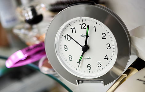 round silver analog clock reading at 7:03 thumbnail