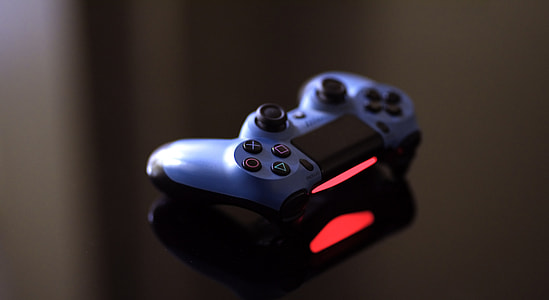 blue and black Sony Dualshock 4 on black surface thumbnail