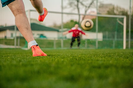 man in red shirt playing soccer thumbnail