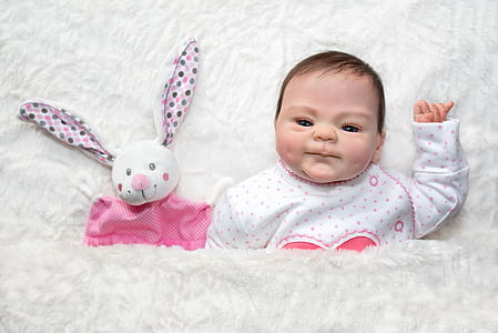 baby beside white rabbit plush toy thumbnail