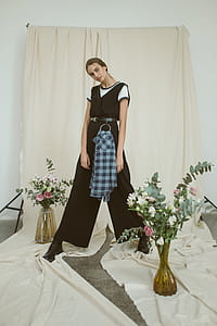 Woman Wearing Black and White Jumpsuit Beside the Curtain thumbnail
