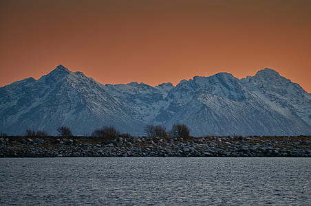 snow covered mountain near body of water thumbnail