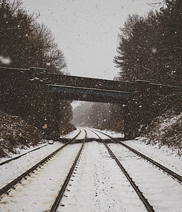 railroad under the bridge with snow falling thumbnail