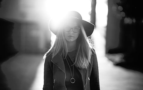 grayscale photography of woman wearing coat and sun hat thumbnail