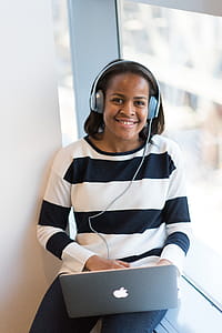 Woman Wearing White And Black Stripe Long-sleeved Shirt Holding Macbook thumbnail