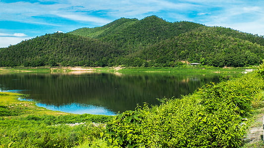 lake in the middle of mountains during daytime thumbnail