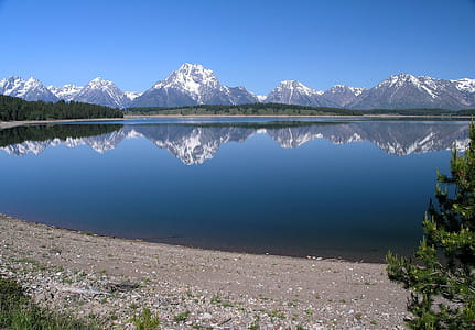reflective photo of mountain and lake during daytime thumbnail