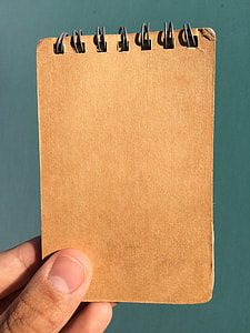 person holding brown book cover thumbnail