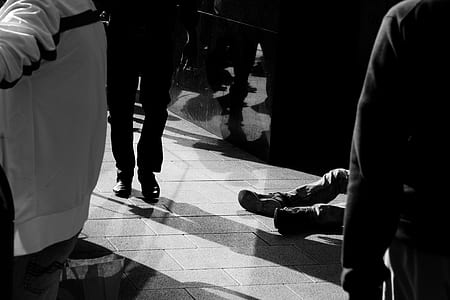 grayscale photography of man on ground near people thumbnail