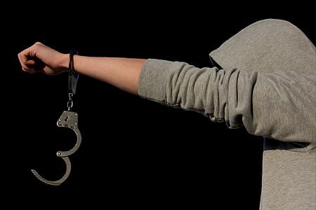 person in gray hoodie wearing handcuffs thumbnail