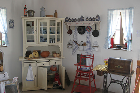 white wooden cabinet beside red toddler's highchair thumbnail