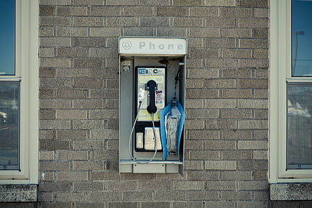 payphone on building's wall at daytime thumbnail