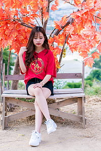 Woman Wearing Red V-neck Shirt Sitting Near Red Leafed Tree thumbnail