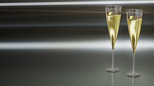 two clear flute glasses filled with yellow liquid thumbnail