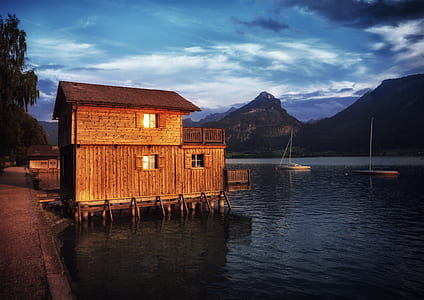 brown wooden hut on shore during daytime thumbnail
