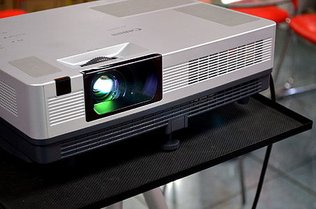 turned-on gray projector on black table thumbnail
