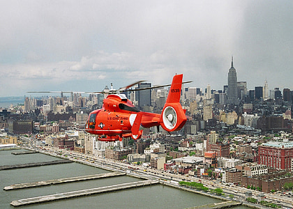 red helicopter flying above city thumbnail