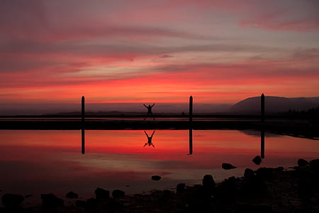 silhouette on person near body of water thumbnail