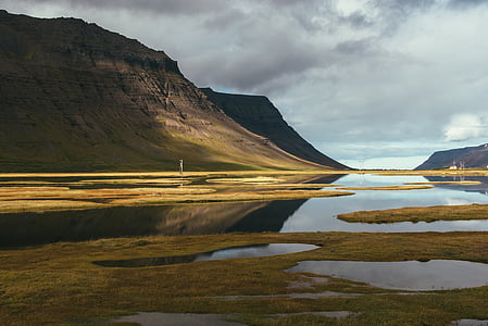calm body of water near mountain thumbnail